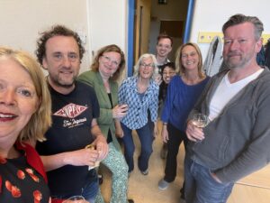 Groep lachende mensen in een ruimte met witte muren